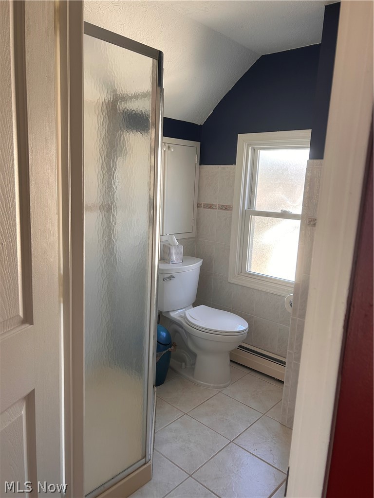 1001 Englewood Road Cleveland Heights, OH 44121 - Photo 20 of 28 Bathroom featuring light tile patterned floors, a baseboard radiator, a shower stall, lofted ceiling, and tile walls