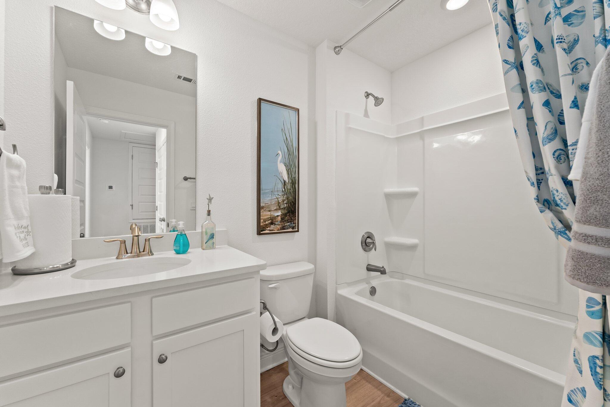 52 Redbird Loop, Unit 54 Destin, FL 32541 - Photo 26 of 30 a bathroom with a granite countertop sink a toilet a mirror a bathtub and shower