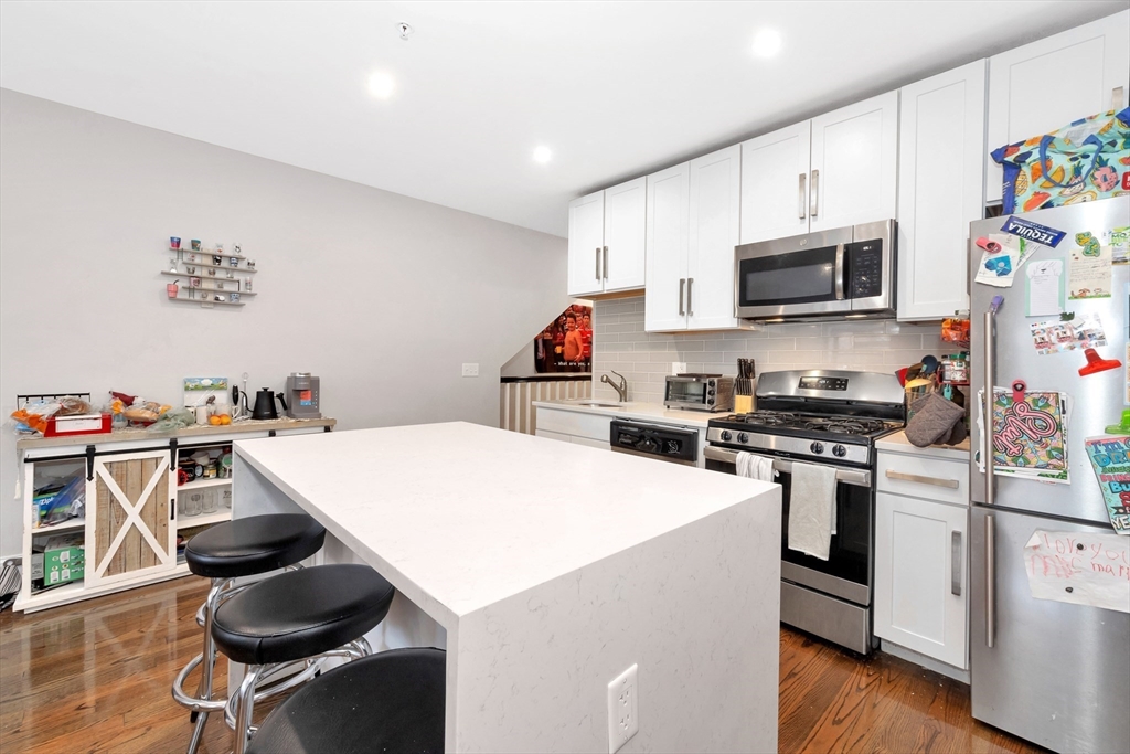 27 Dudley Street Boston, MA 02119 - Photo 26 of 42 a kitchen that has a lot of cabinets and appliances