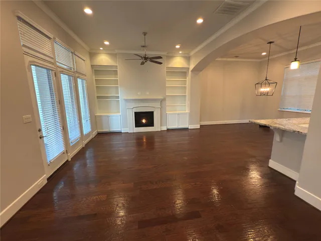 a view of empty room with wooden floor and fireplace