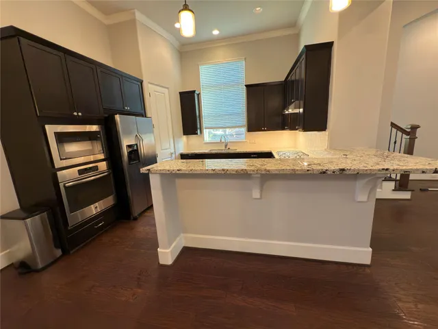a kitchen with stainless steel appliances granite countertop a stove a sink and a refrigerator