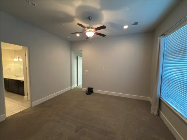 an empty room with closet and a chandelier fan