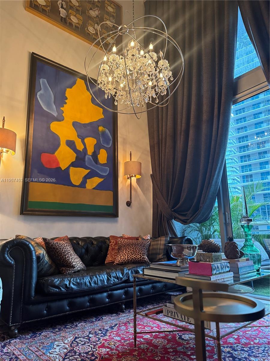 1050 Brickell Avenue, Unit 818 Miami, FL 33131 - Photo 1 of 19 a living room with furniture a chandelier and a rug