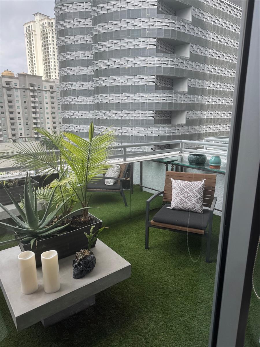 1050 Brickell Avenue, Unit 818 Miami, FL 33131 - Photo 3 of 19 a living room with furniture and a floor to ceiling window