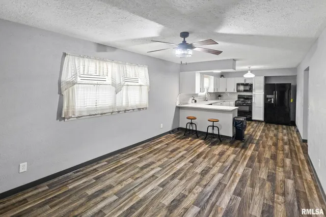 a view of kitchen island with sink and wooden floor