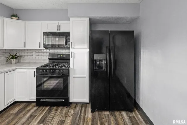 a kitchen with granite countertop white cabinets and sink