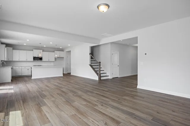 a view of a kitchen with wooden floor and a sink