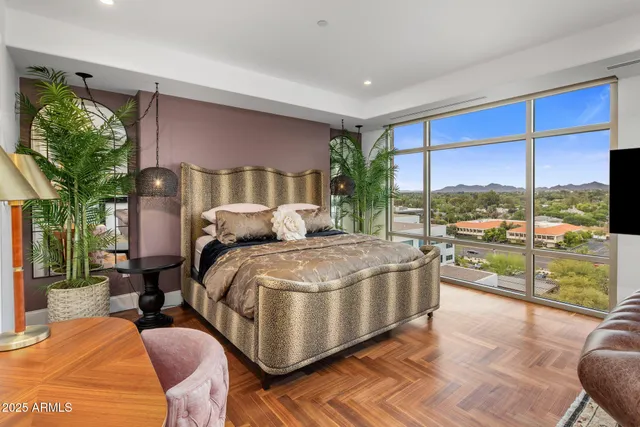 a bed sitting in a bedroom next to a large window with garden view