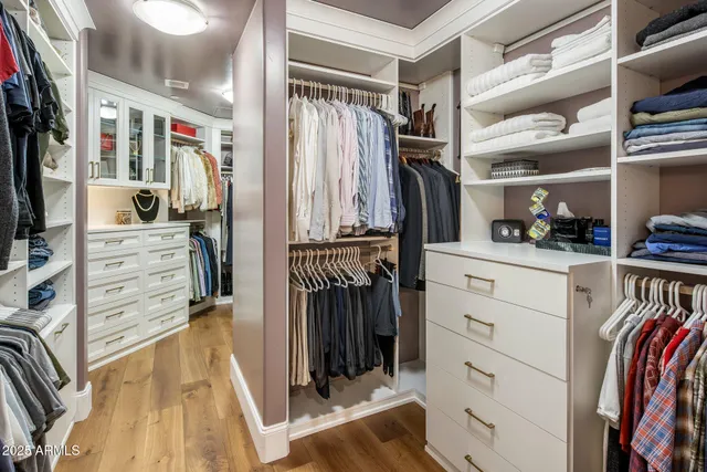 a view of walk in closet with clothes and shoes
