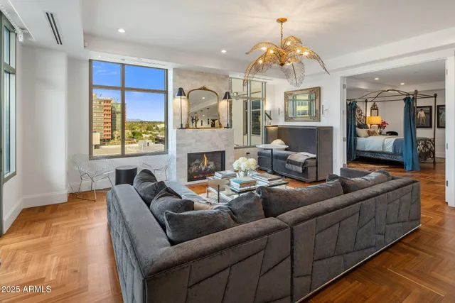a living room with furniture a fireplace and a chandelier