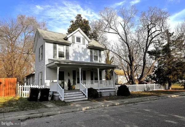 a view of a white house with large windows and a large tree