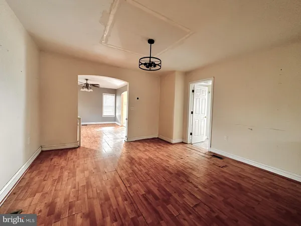 a view of an empty room with window and wooden floor
