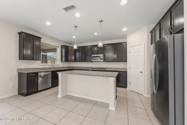 a kitchen with kitchen island a counter top space appliances and a center island