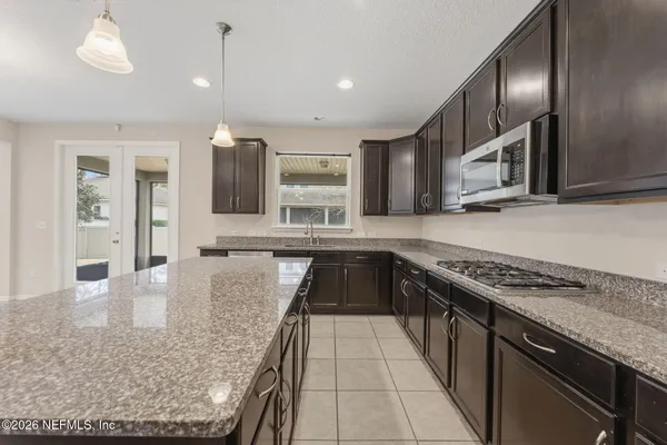a kitchen with kitchen island white cabinets and stainless steel appliances