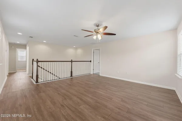 a view of an empty room with wooden floor