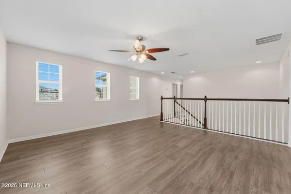 an empty room with windows and fan
