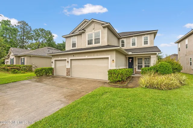 a front view of a house with a yard and garage
