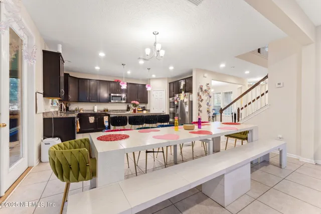 a living room with stainless steel appliances furniture and a kitchen view