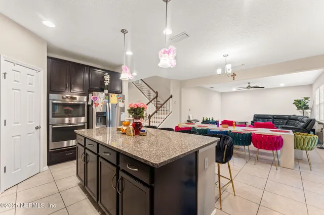 a kitchen that has a lot of cabinets and refrigerator in it