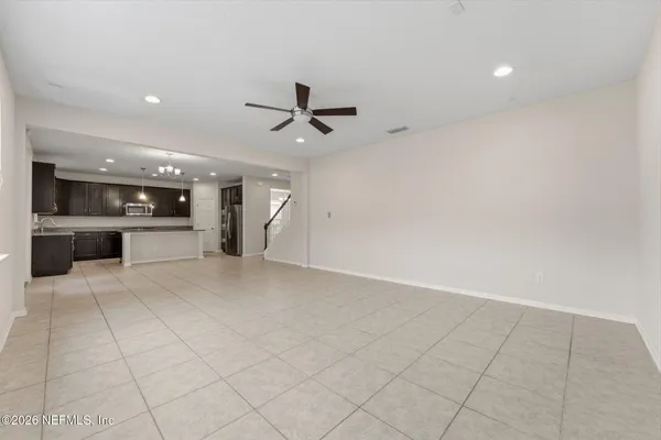 a large kitchen with stainless steel appliances kitchen island granite countertop a stove a sink dishwasher and a refrigerator with wooden floor