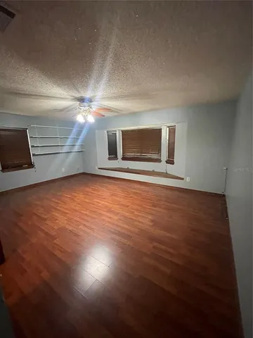 a view of a room with wooden floor and door