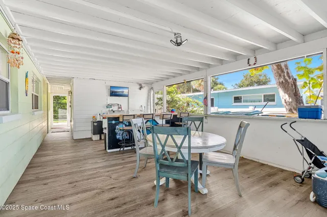 a dining hall with stainless steel appliances a dining table and chairs with wooden floor