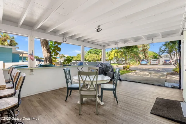 a view of a dining room with furniture large windows and wooden floor
