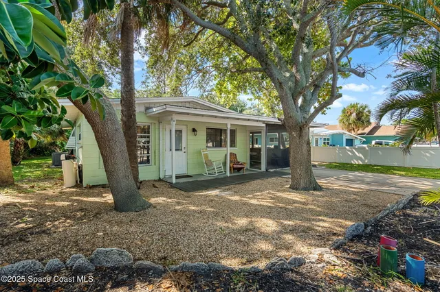 a view of a house with backyard and tree