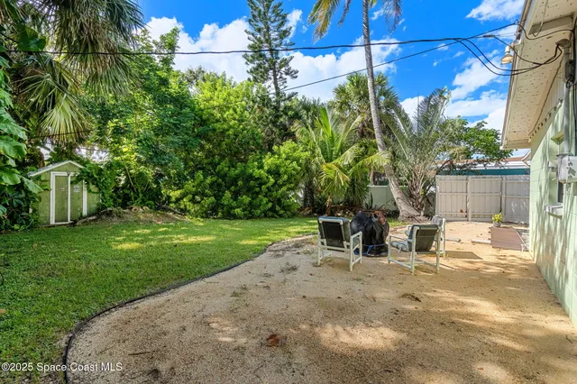 a view of a backyard with plants and outdoor seating