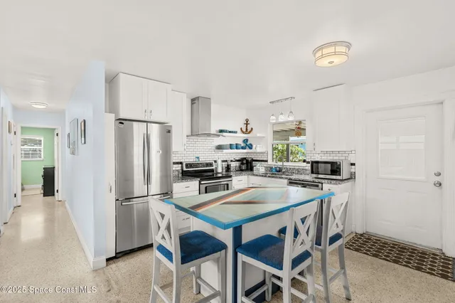 a kitchen with stainless steel appliances a refrigerator a stove a sink and a refrigerator