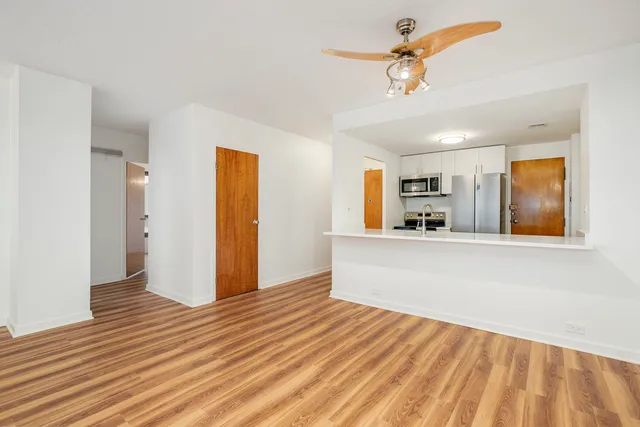 a view of a kitchen with wooden floor and a ceiling fan