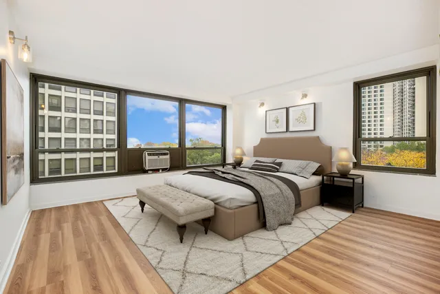 a bedroom with a bed and a large window