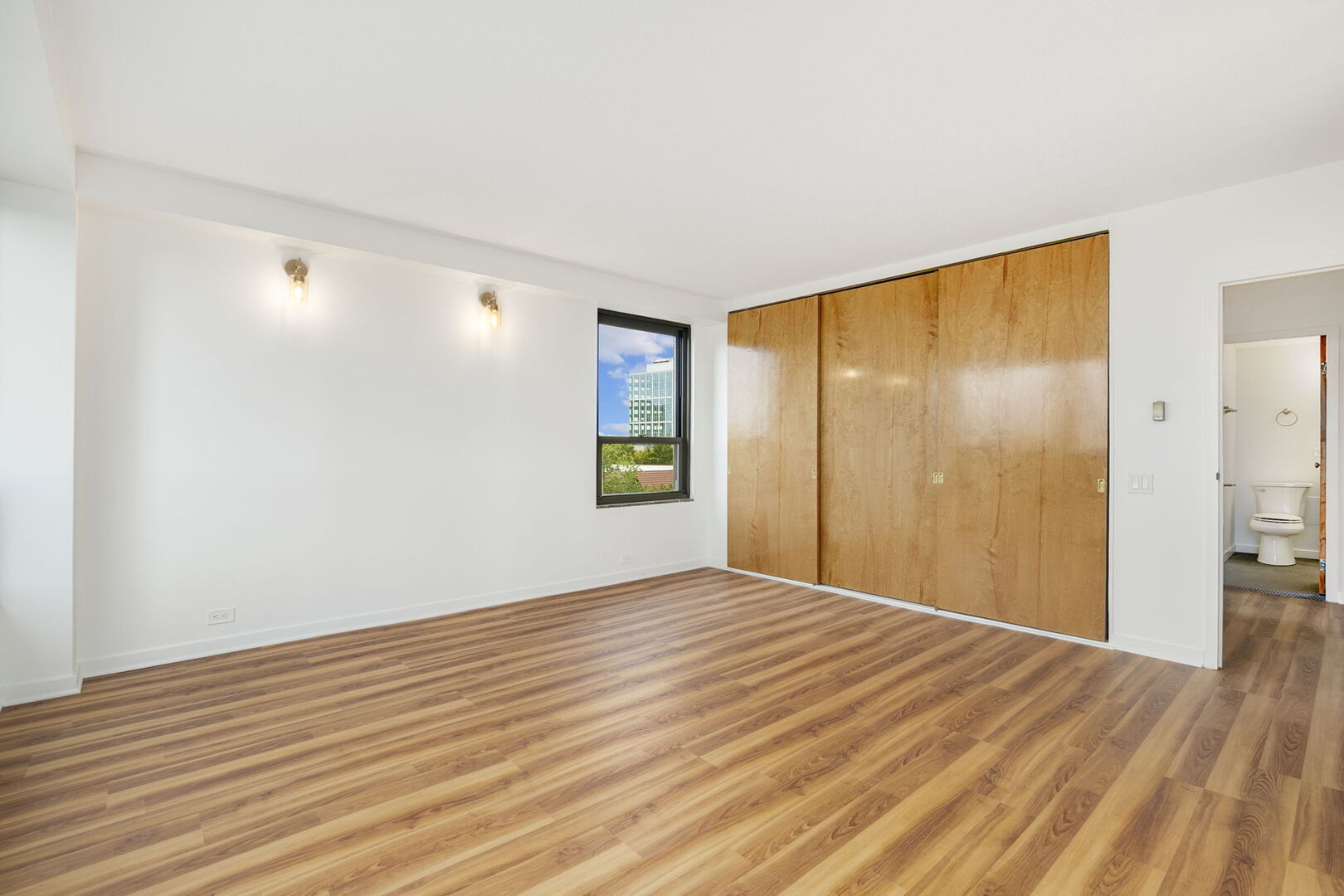 5050 South East End Avenue, Unit 7A Chicago, IL 60615 - Photo 13 of 24 a view of an empty room with wooden floor and a window