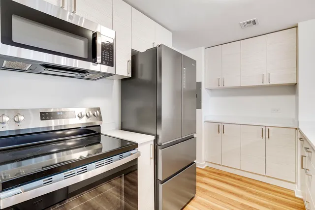 a kitchen with stainless steel appliances a refrigerator stove and microwave