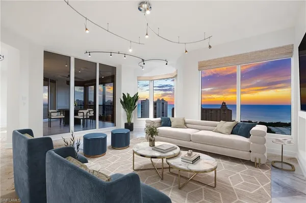 a living room with furniture ceiling fan and a large window