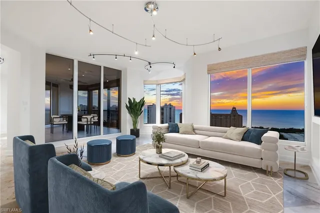a living room with furniture ceiling fan and a large window