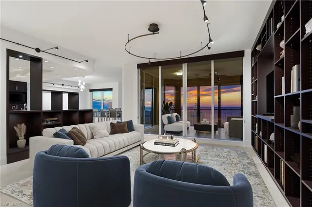 a living room with furniture ceiling fan and a large window