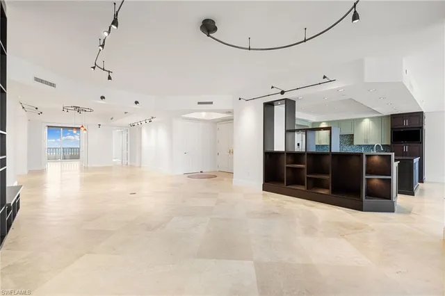 a view of an empty room with furniture and a window