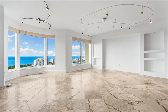 a view of empty room with wooden floor and windows