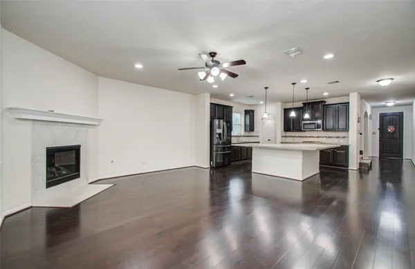 a view of an empty room with a chandelier fan
