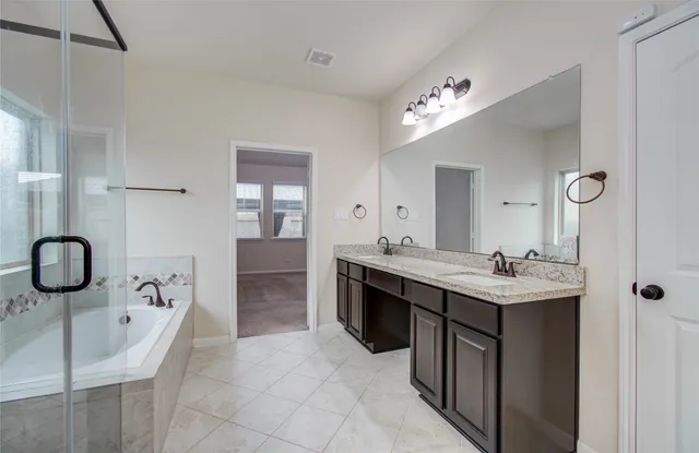 a bathroom with a sink double vanity granite tub and shower
