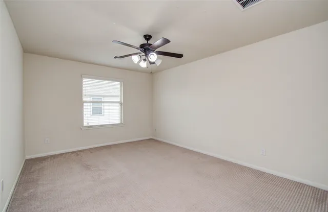 an empty room with a window and a fan