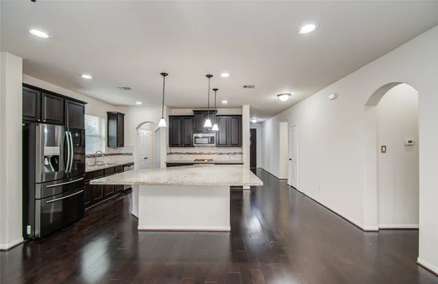 a kitchen with stainless steel appliances kitchen island a refrigerator and a stove top oven