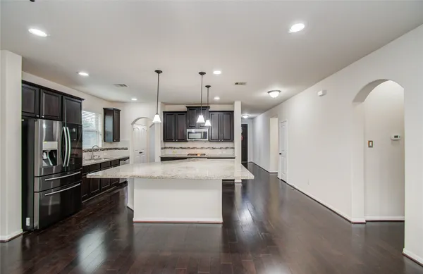a kitchen with stainless steel appliances granite countertop a sink and wooden cabinets