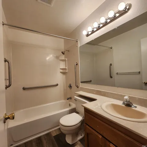 a bathroom with a sink a toilet a mirror and shower