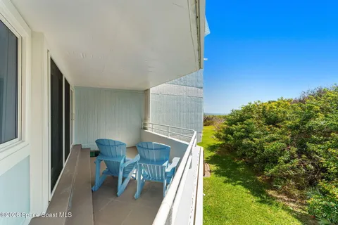 a balcony with table and chairs
