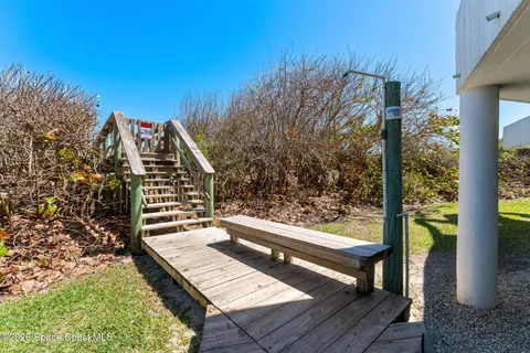 a view of a balcony with chairs and wooden fence