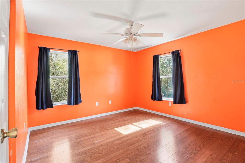8006 Southwest 62 Lane Gainesville, FL 32608 - Photo 12 of 17 an empty room with wooden floor fan and windows