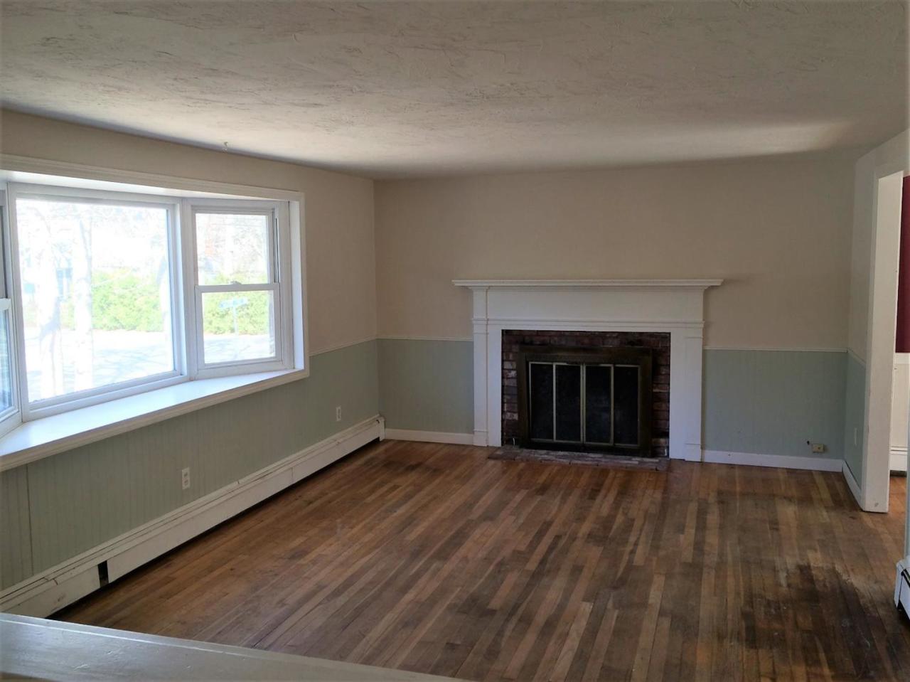 6 Crooked Pond Road Hyannis, MA 02601 - Photo 2 of 10 an empty room with wooden floor fireplace and windows