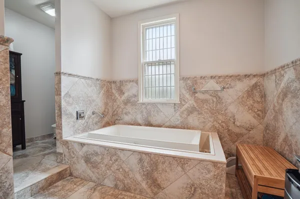 a bath tub sitting in a bathroom next to a window